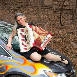 Jeanne on a car hood with her accordion